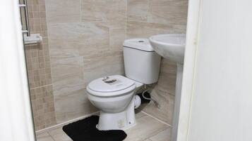 Ein Badezimmer mit Toilette, Waschbecken und Fliesenwänden.