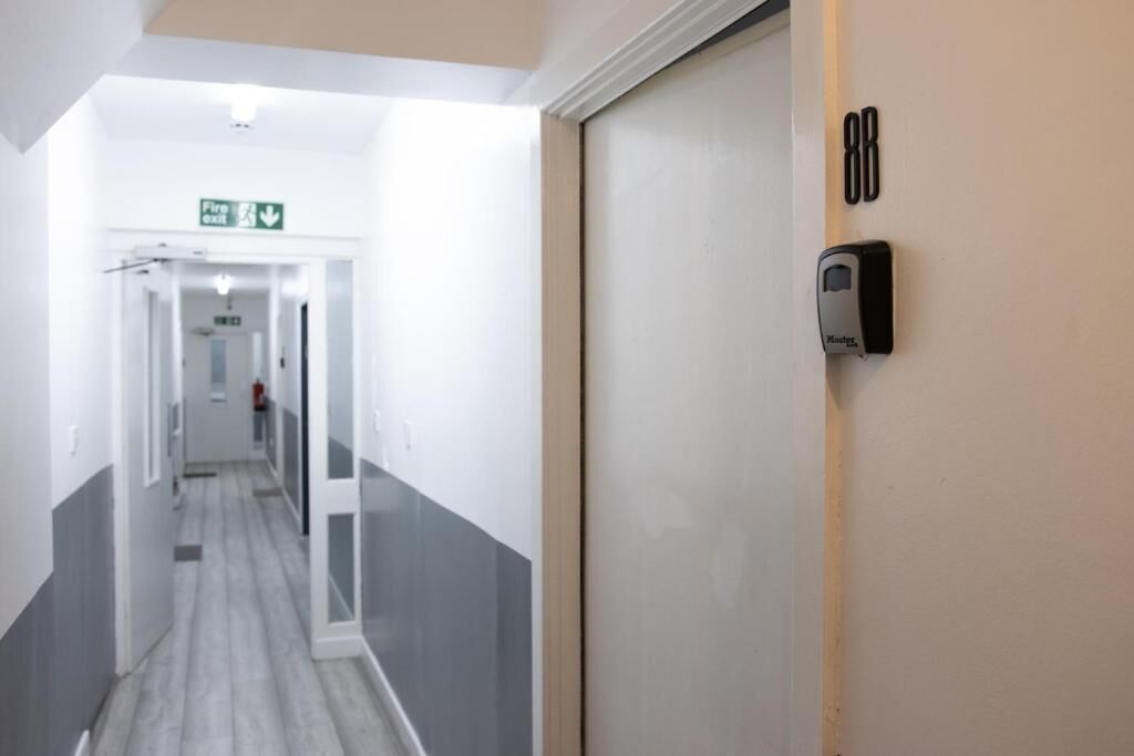 Un pasillo con una puerta marcada con el número 88 y un letrero de salida de incendios.