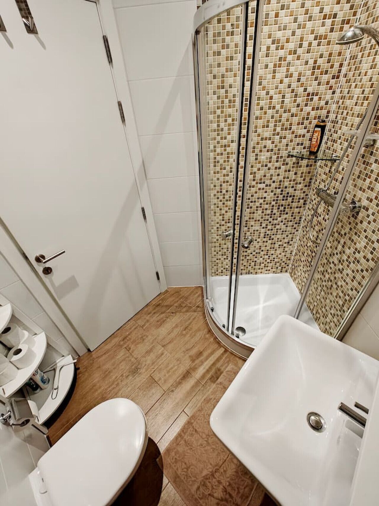 Ein Badezimmer mit Dusche, zwei Waschbecken und Toilette.