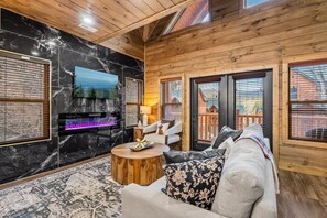 Una sala de estar acogedora con chimenea, televisor y un espacio de descanso confortable.