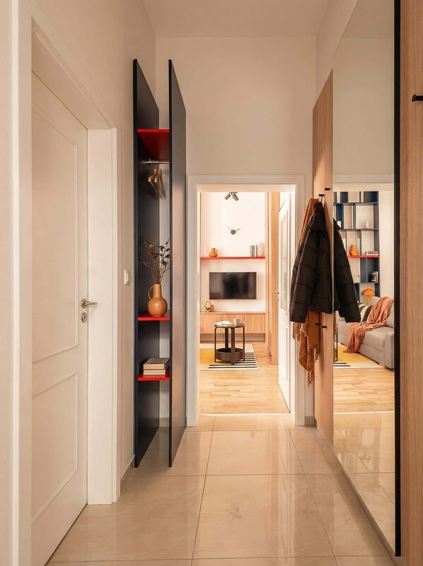 A modern hallway with a TV, shelves, and a sofa in the background. - TurnKey | Wenceslas square Loft Apartment V (Praha 1)
