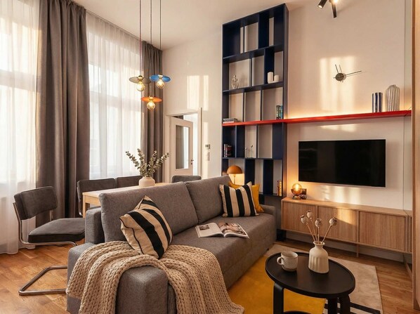 Un salon moderne avec un canapé gris, une table basse et une bibliothèque.