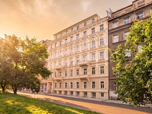 Un immeuble à plusieurs étages, de style architectural classique, caractérisé par des fenêtres disposées de manière symétrique et des moulures décoratives.