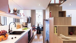 Eine moderne Küche mit eingebautem Geschirrspüler, einer Spüle und einem Essbereich mit Tisch und Stühlen.