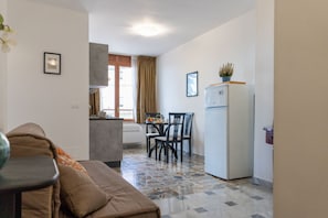 Ein gemütlicher, kleiner Wohnbereich mit Küchenzeile, Essplatz und einer Couch.
