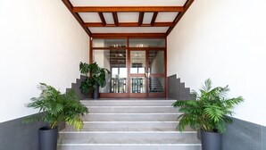A staircase leading to a building entrance with glass doors and a wooden frame.
