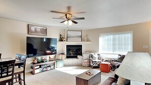 A living room with a TV, fireplace, sofa, and coffee table.