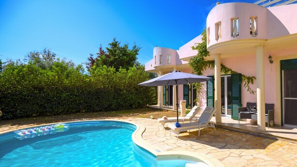 A poolside area with a swimming pool, lounge chairs, and a covered seating area.