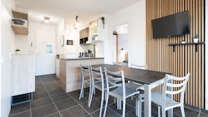 A modern kitchen with a central island, white chairs, and a dining table. - Magnificent villa with garden for 9 people (Sérignan)