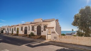 A coastal building with a tiled roof, a gated entrance, and a sign reading "Pueblo Chimenea". - Cozy home in Nerja with WiFi (Nerja)