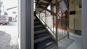 Eine Treppe mit Metallgeländern führt zu einer Tür mit einem Fenster.