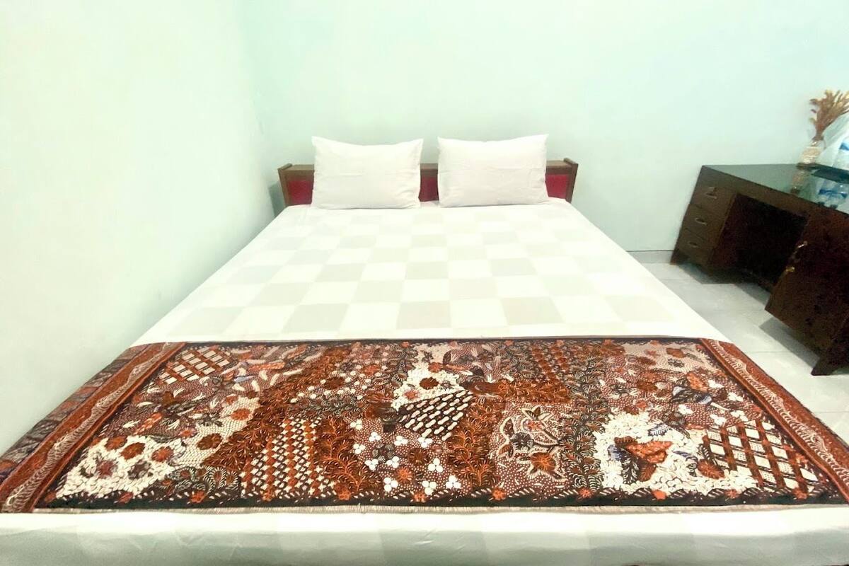 A bed with a checkered bedspread and a patterned throw blanket.