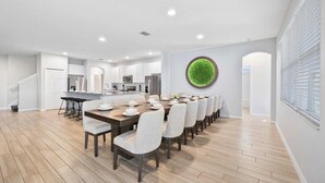 A modern kitchen with white cabinets, stainless steel appliances, and a central island.