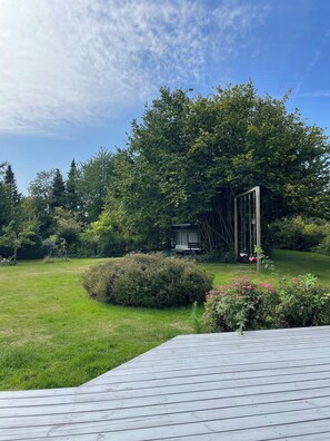 A wooden deck, a garden with a swing set, and a gazebo.