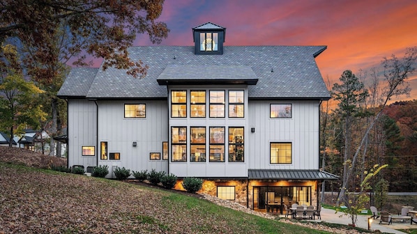 A modern two-story house with a large front porch and multiple windows.
