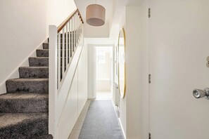 A staircase leading to a door with a mirror and a light fixture above it. - Extravagant 6 Bedroom Mansion by Mayfair London (London)