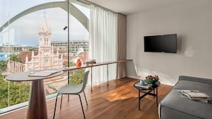 A modern living room with a balcony, a flat-screen TV, a dining table, and a sofa. - M Village Hotel Đà Nẵng Centre, a brand of Modern Village Lifestyle (Da Nang)