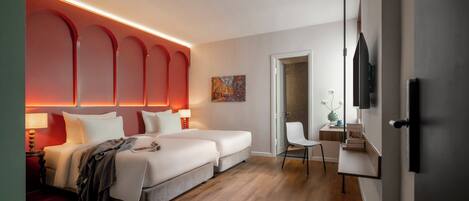Une chambre d’hôtel moderne avec un grand lit, deux tables de chevet, un bureau et une chaise.