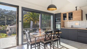 A modern kitchen with dark cabinetry, a wooden countertop, and a pendant light. - Maison Fabrégas by Interhome (La Seyne Sur Mer, Les Sablettes)