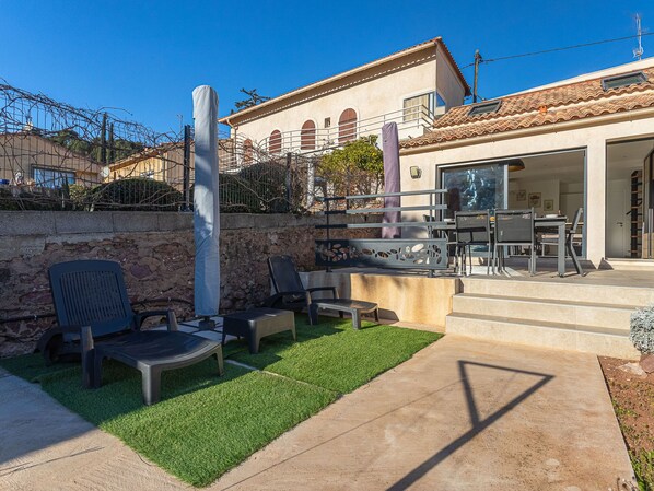 A patio area with outdoor furniture, a stone wall, and a building with a tiled roof. - Maison Fabrégas by Interhome (La Seyne Sur Mer, Les Sablettes)