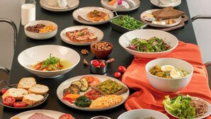 A dining table with various dishes and a painting above it. - Signature by M Village Danang Heritage, a brand of Modern Village Lifestyle (Da Nang)