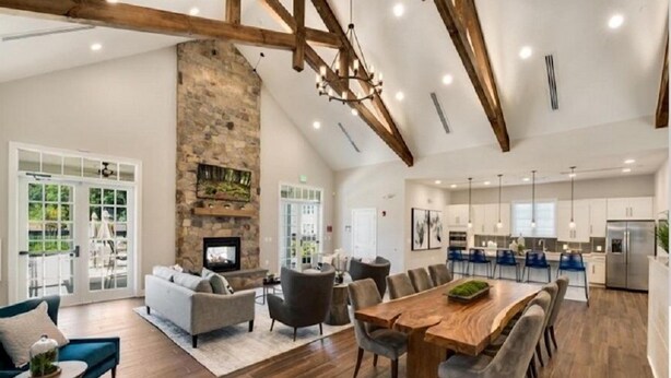 A spacious living area with a fireplace, a dining table, and modern furniture. - 5-Star BWI Hanover 3-Level With Bonus Living Space (Hanover)