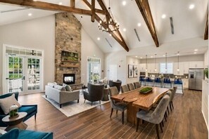 Un sal ón amplio con chimenea, una mesa de comedor y muebles modernos.