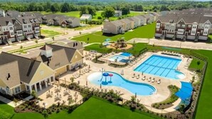 A residential complex with a central swimming pool, multiple houses, and a well-maintained lawn. - 5-Star BWI Hanover 3-Level With Bonus Living Space (Hanover)