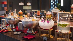 Ein reichhaltiges Buffet mit verschiedenen Speisen und Getränkeausgabestationen, darunter eine große Schüssel mit Eis und mehrere Flaschen Getränke.