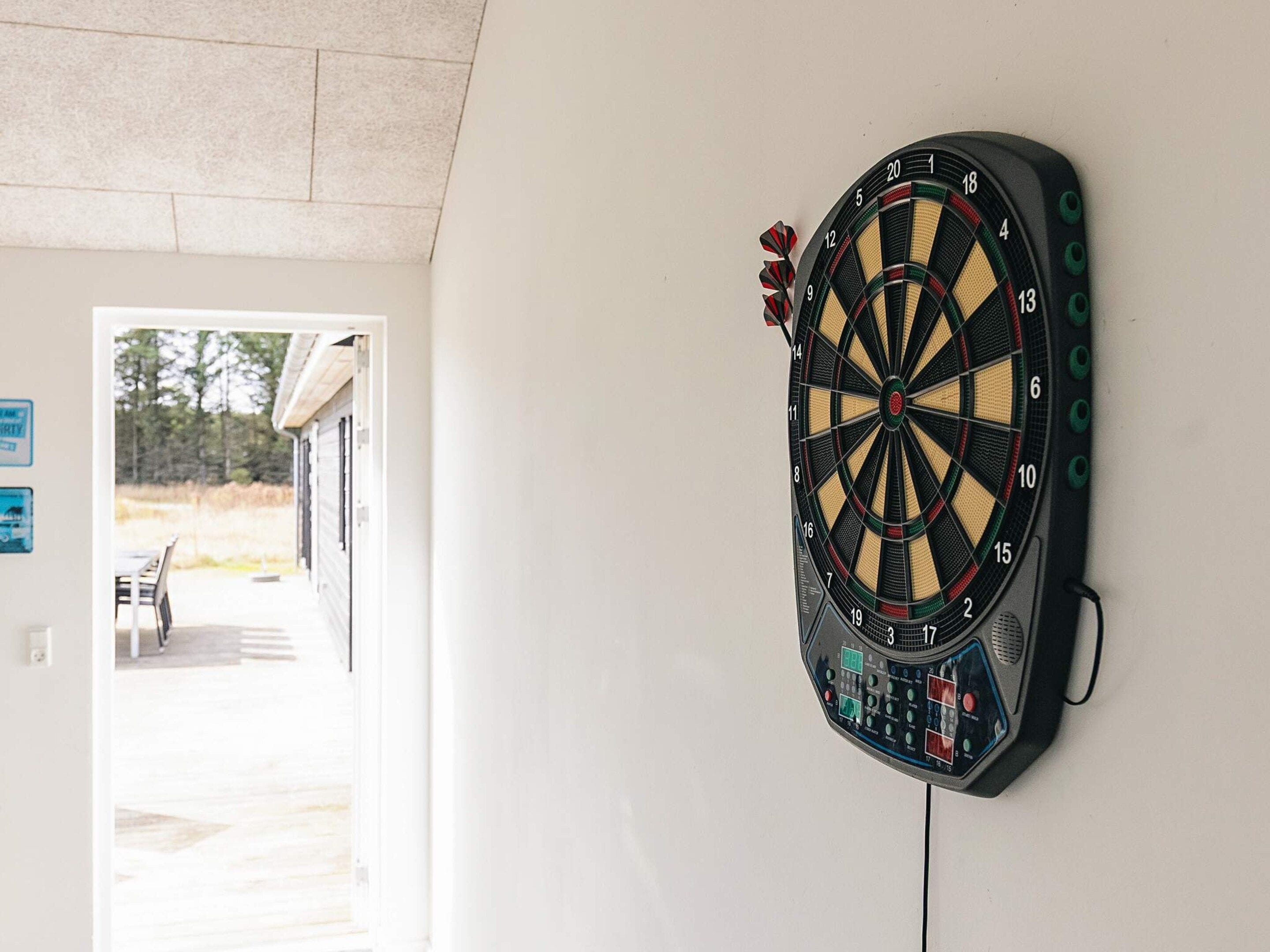 Un dardo fijado en una pared con una puerta que da a un espacio exterior.
