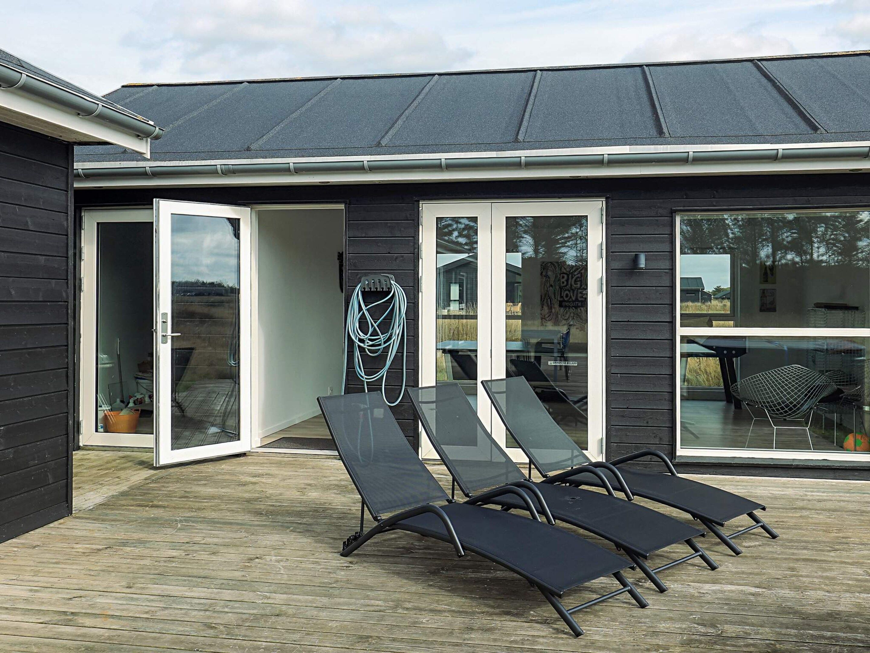 Moderni talo, jossa on terassi, ulkotila oleskelua varten ja avoin näkymä ympäröivään maisemaan.