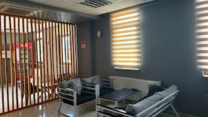 Una habitación moderna con sofá, una mesa y ventana con persianas.