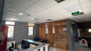 Una moderna zona de recepción con escritorio, sillas y un panel de madera.