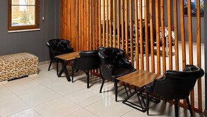 Una habitación moderna con un separador de madera, un ventanal grande y un comedor con sillas y mesa.