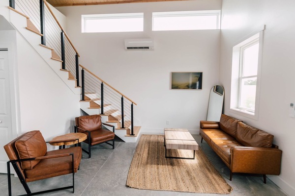 Living room with leather sofa and stairs to the loft