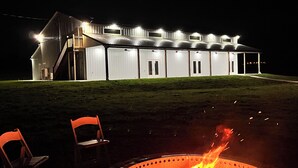 A building with a fire pit and two chairs in front. - Riverbend Ranch Cabin #1 (Normandy)