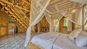 Una habitación con una cama, una escalera de madera y una cama con dosel.