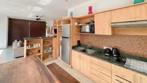 A modern kitchen with wooden cabinets, a stainless steel refrigerator, and a microwave. - 3BR Del Mar Tropical Villa 4 in Seminyak Beach (Seminyak)