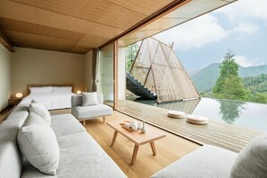 Enjoy a serene atmosphere in this stylish bedroom with a large window, comfortable bed, and cozy seating area.