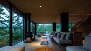 A modern interior with a large window, a wooden table, and a sofa.