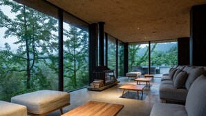 A modern living room with large windows, a fireplace, and a sofa. - Origin Villa Hotel (Hangzhou)