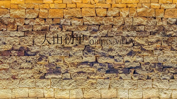 Exterior of a traditional building with a rustic stone wall.