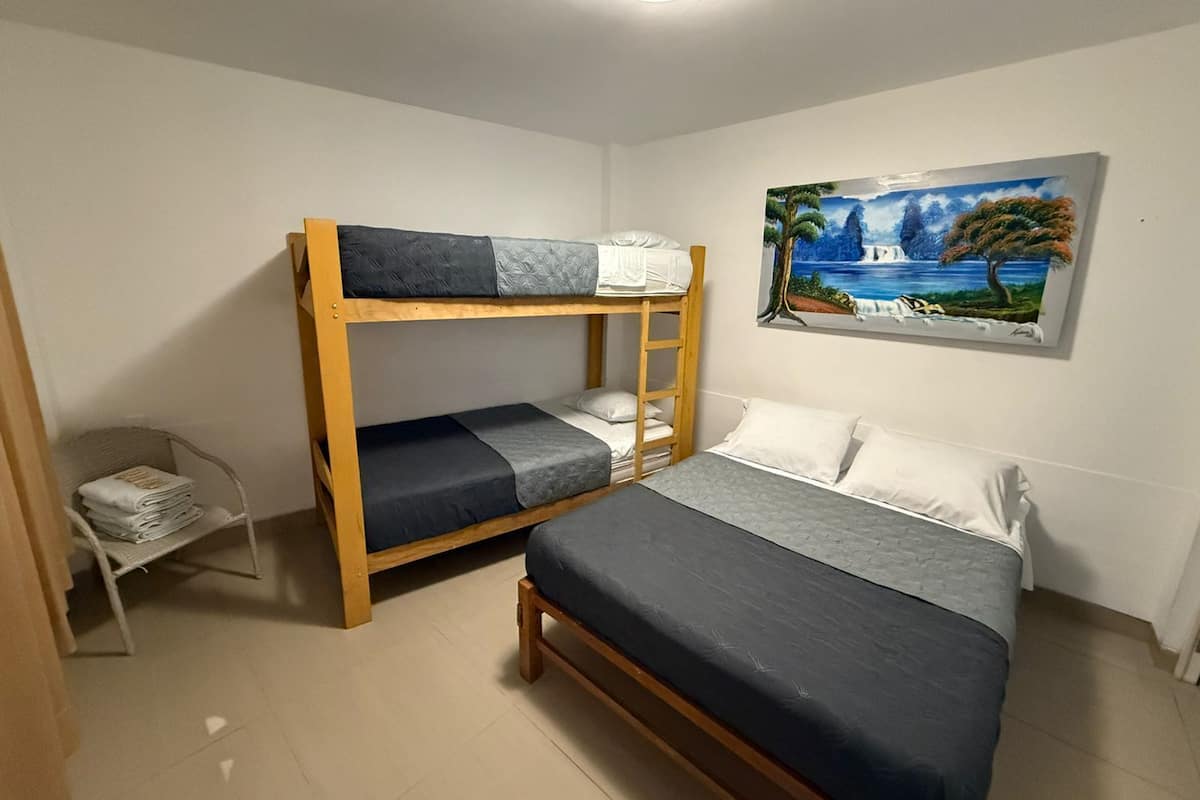 A bunk bed room with a painting of a landscape on the wall.