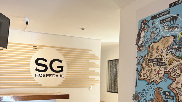 A reception area with a modern design, including a reception desk, a wall-mounted map, and a seating area with a bench. - SGH Paracas (Paracas)