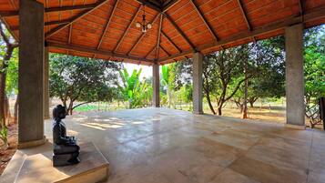 Relax in a serene outdoor space surrounded by lush greenery and a central statue.