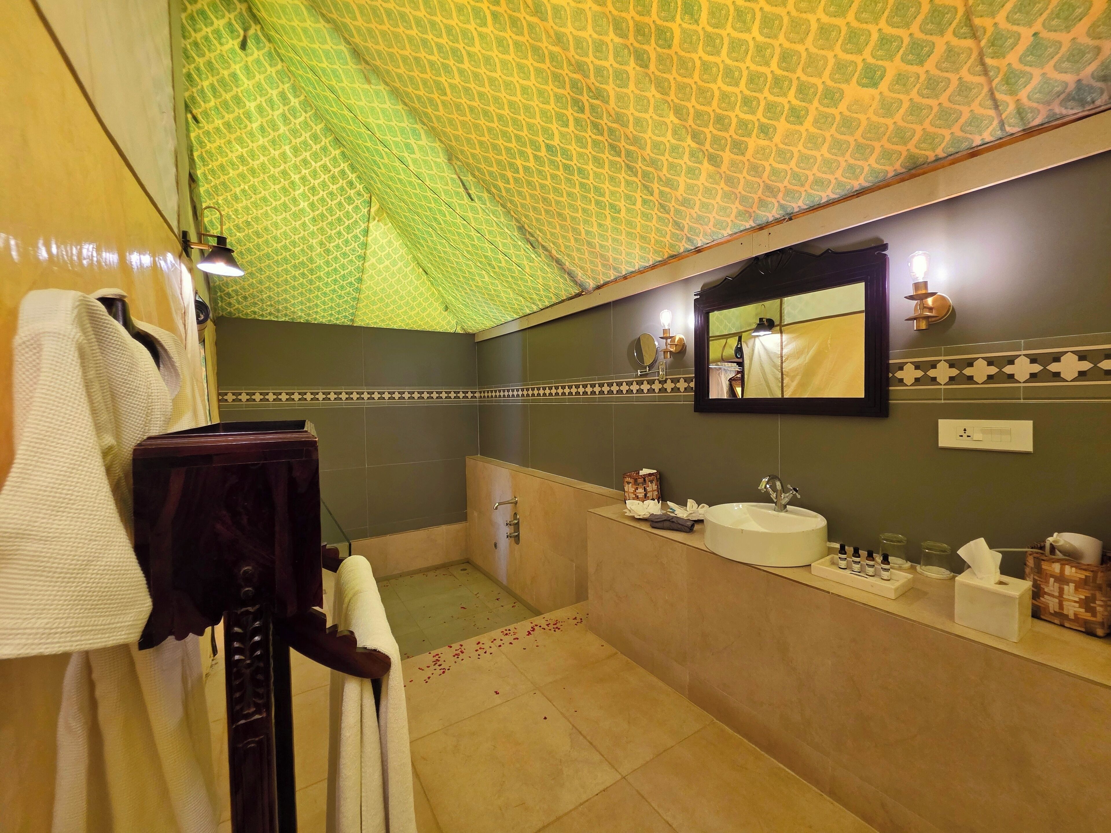 A bathroom with a large mirror, a sink, and a towel rack.