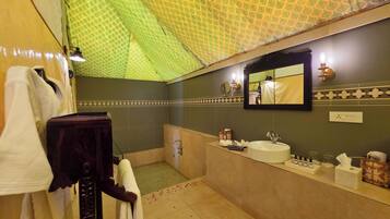 A bathroom with a large mirror, a sink, and a towel rack.