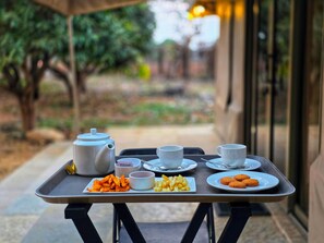 A tray with a teapot, cups, and plates of food on a table outside. - Angirasa Luxury Camping (Kondapak)