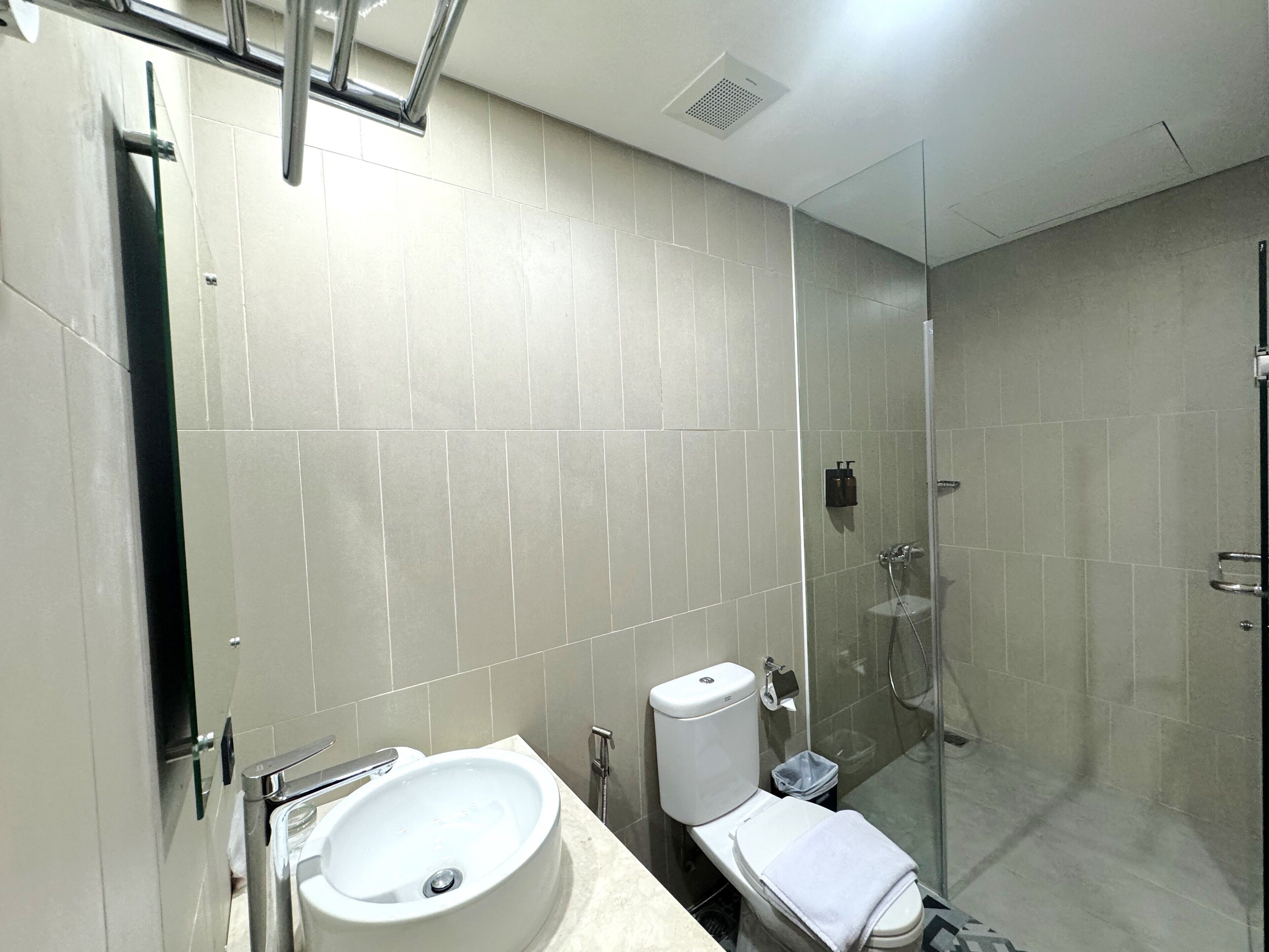 A modern bathroom with a sink, toilet, and glass-enclosed shower.