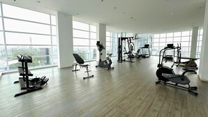 A spacious gym with various exercise equipment, large windows, and a high ceiling. - Howard Johnson by Wyndham Tangerang (Tangerang)